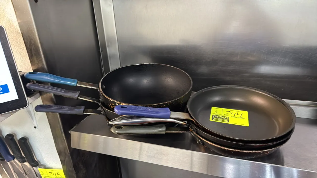 Aluminum frying pans. Features non-stick interior coating, riveted handles, and silicone handle grips. Includes deep and shallow skillet designs. Dime
