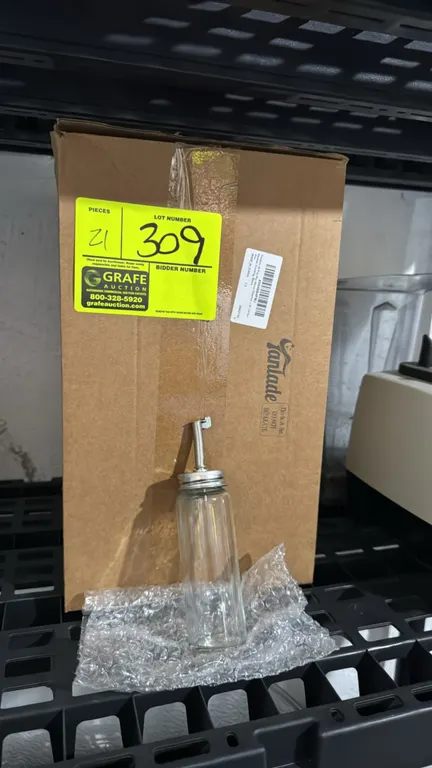 Tanlade glass soy sauce dispensers. Features clear glass bodies with screw-on metal pour spouts and hinged flap caps. 5"H.