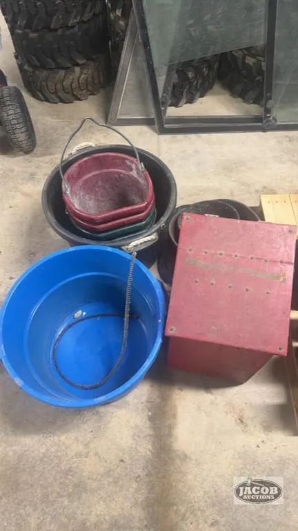 Pile of feed/water buckets and storage box