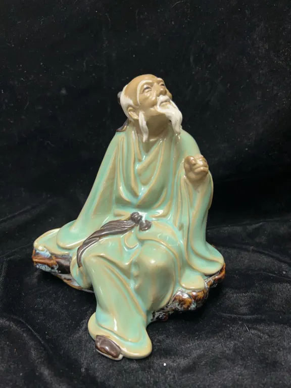 Glazed Ceramic Figurine of Elderly Man Seated on Rock