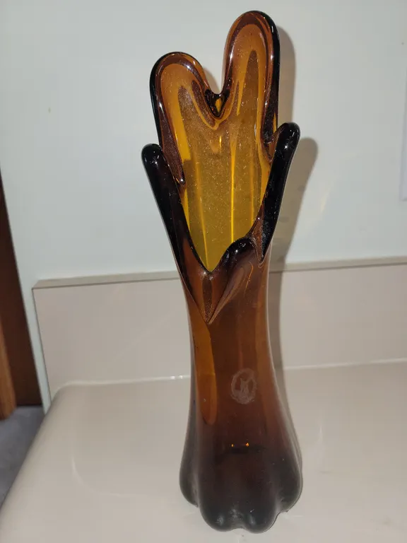 This is a vintage mid-century modern amber glass swung vase featuring a distinctive five-finger flar