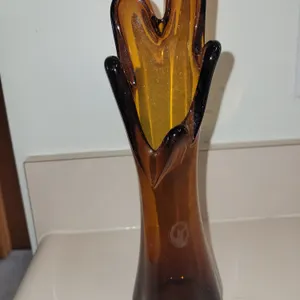 This is a vintage mid-century modern amber glass swung vase featuring a distinctive five-finger flar