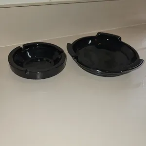 2 vintage black ashtrays. Larger one has a crack/scratch.