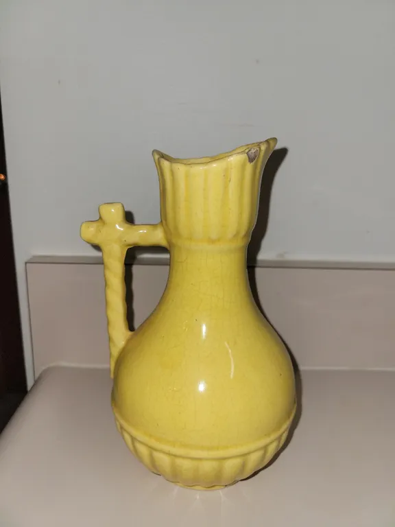show a vintage yellow glazed ceramic pitcher vase with a twist handle, resembling mid-century art po