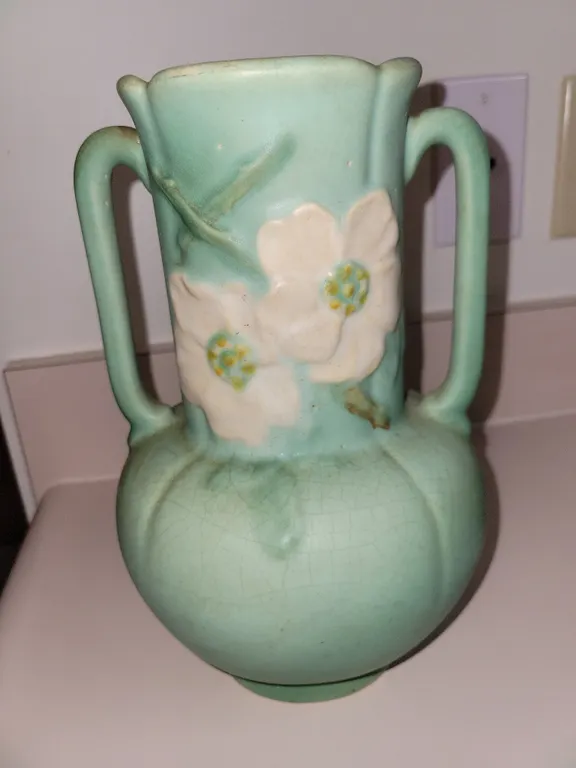 vintage double-handled matte green art pottery vase with raised floral decoration, closely resemblin