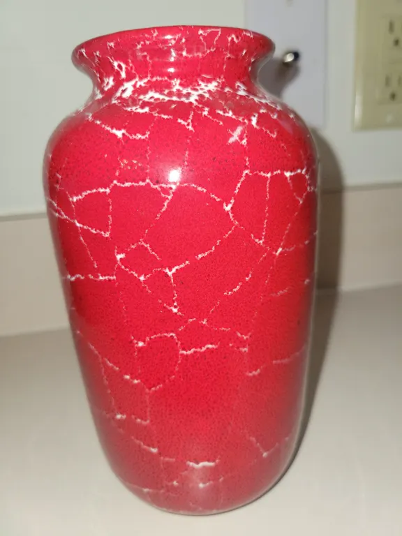 red ceramic or glass vase with a white crackle-glaze or marbled pattern.