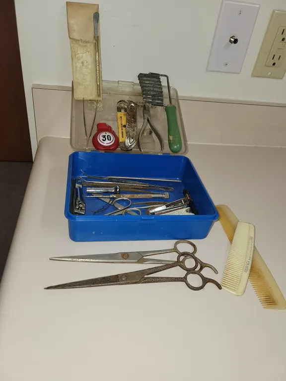 vintage blue plastic storage or tackle box filled with an assortment of small personal grooming item