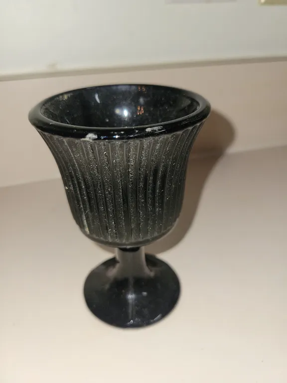 vintage Indiana Glass black glass footed tea light or votive candle holder featuring ribbed or flute