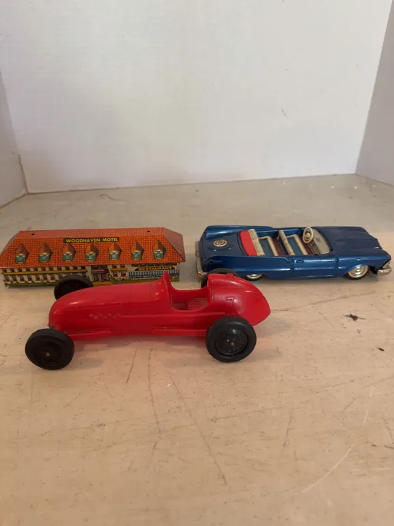 2 Toy Cars And A Metal Toy Hotel