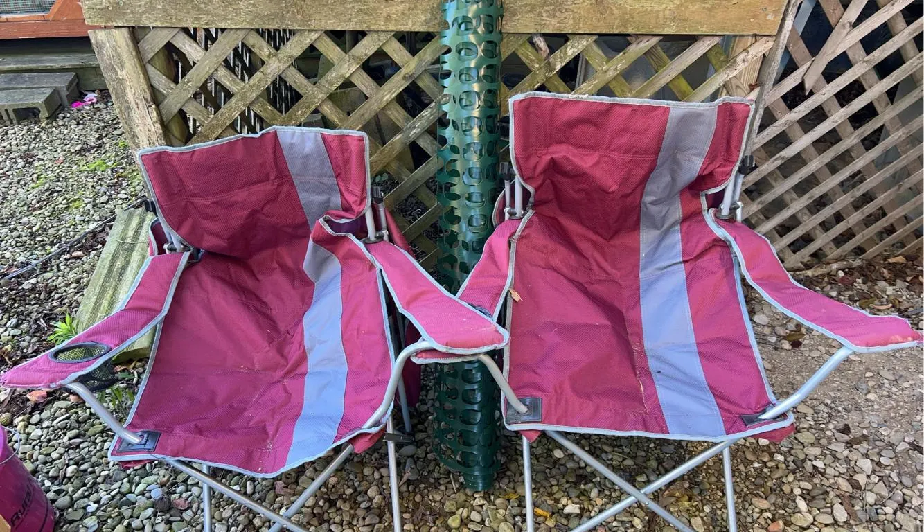 Two camping chairs and green snow fence