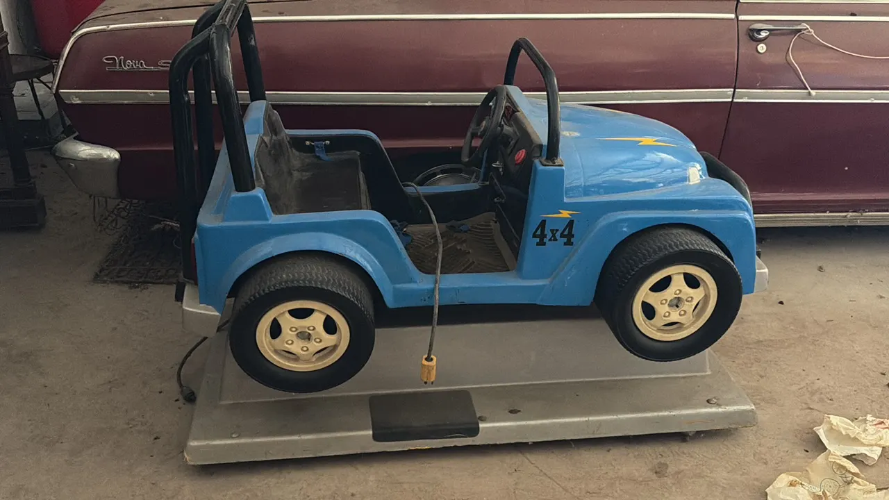 Jeep-style coin-operated kiddie ride, blue, with lightning bolt decals, '4x4' graphics, and 1 coin mechanism