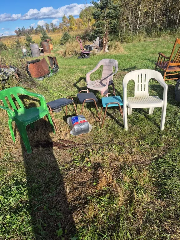 3 lawn chairs, plastic, 3 stools and a role of pipe installation.