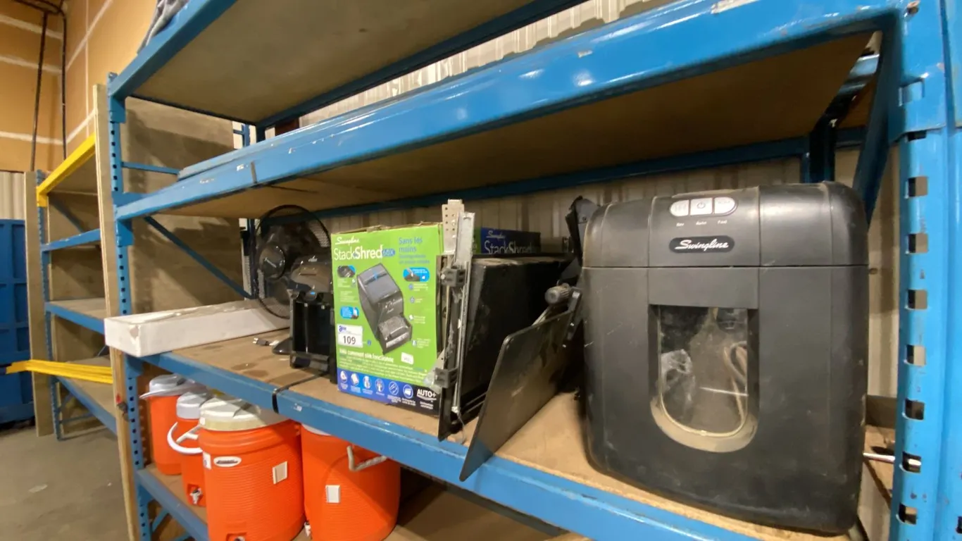 SHELF OF ASSORTED OFFICE ITEMS- PAPER SHREDDERS, TABLETOP FAN, VITAPUR WATER DISPENSER, KEYBOARD