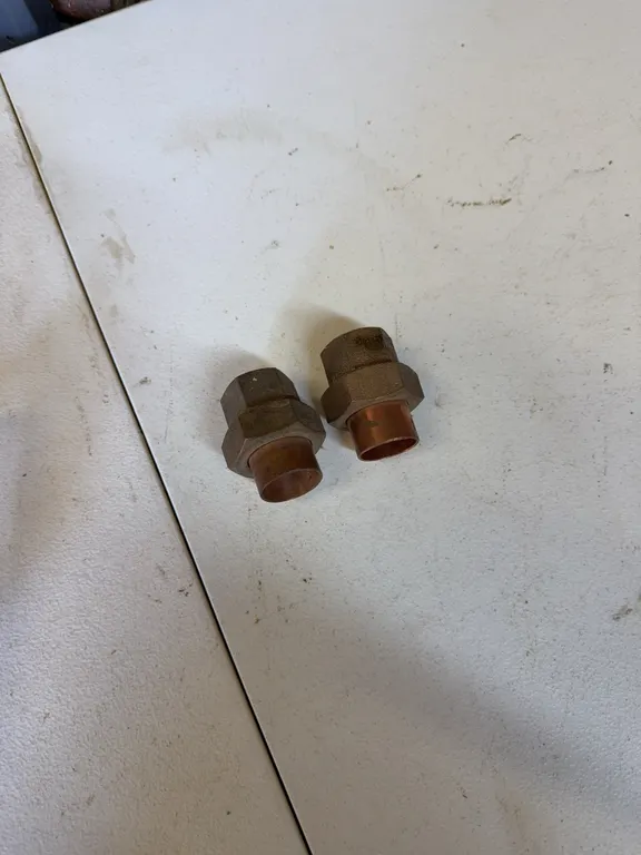 Two copper and brass unions