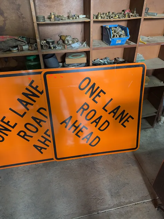 Two Metal one lane road ahead signs