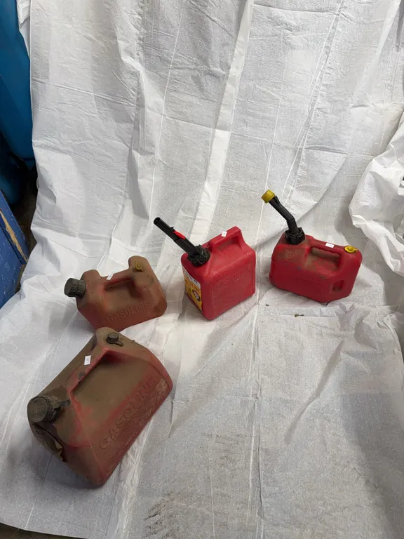 3 1 gallon gasoline cans, one 2 gallon gasoline can