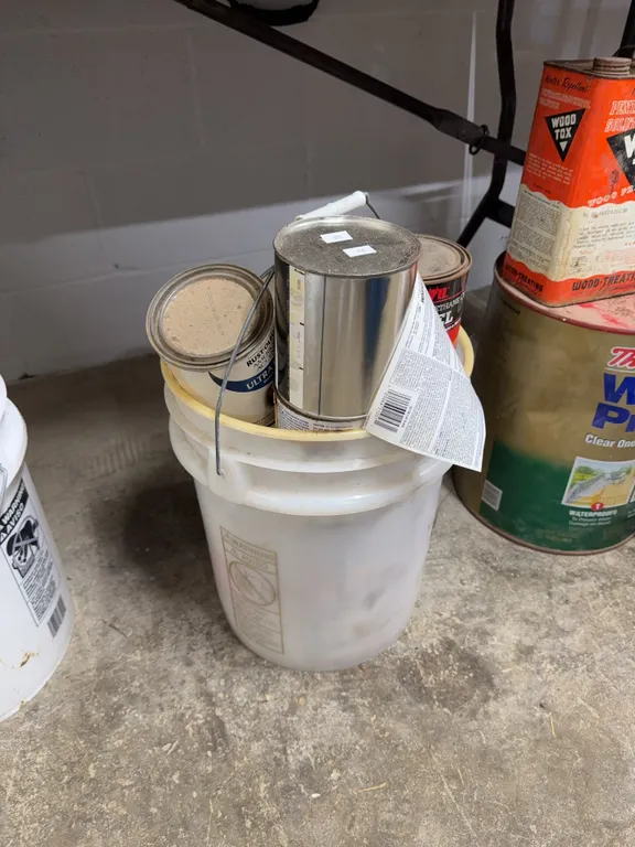 5 gallon bucket filled with paint and enamel supplies