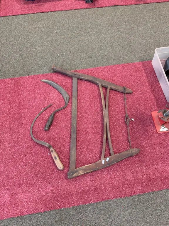 Antique bucksaw and hand sickles