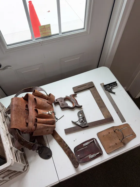 Three construction rulers, leather nail bag