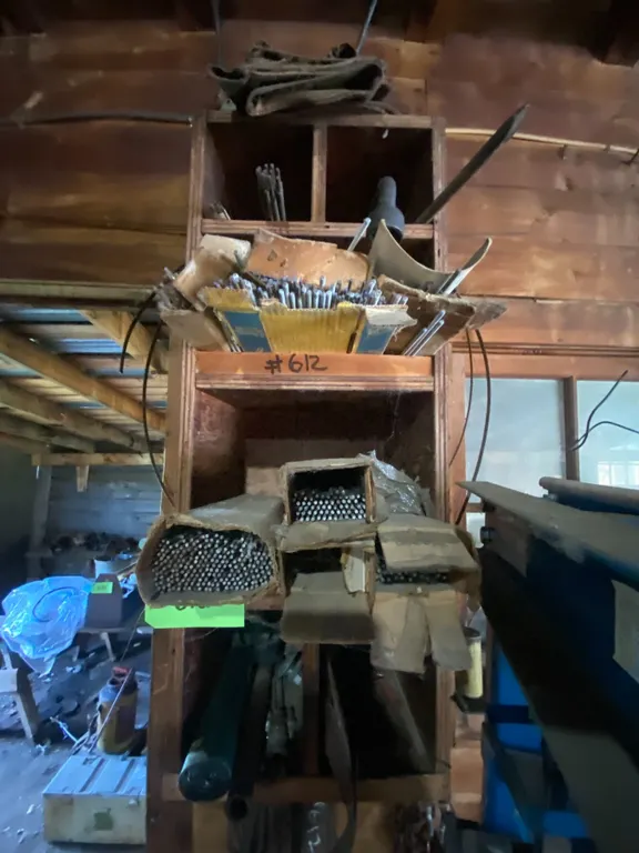 Qty of welding rods, misc. chain, brazing rod, cable & contents on East wall