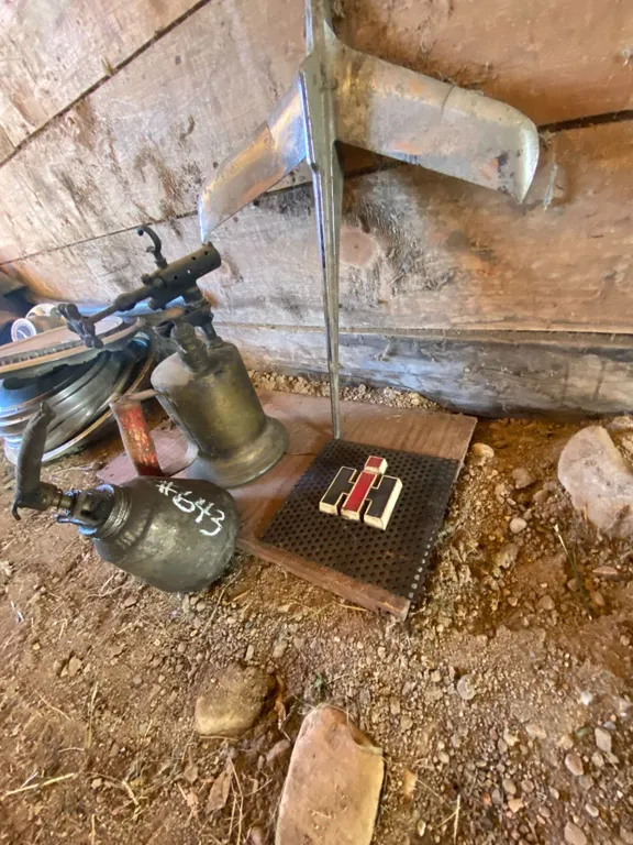 Blow torch, hood ornament, IH emblem & automotive parts on the wall
