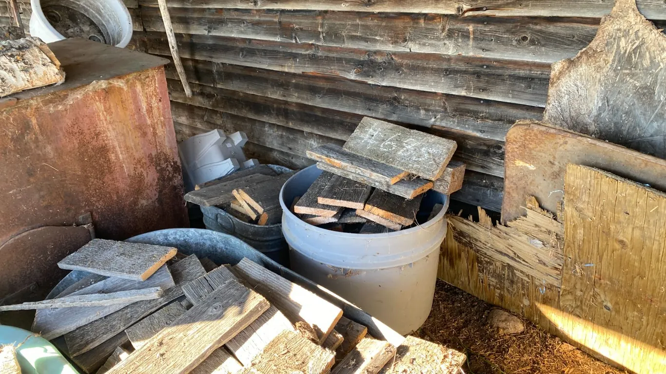 Totes of firewood, saw horse, plastic barrel, misc. wood