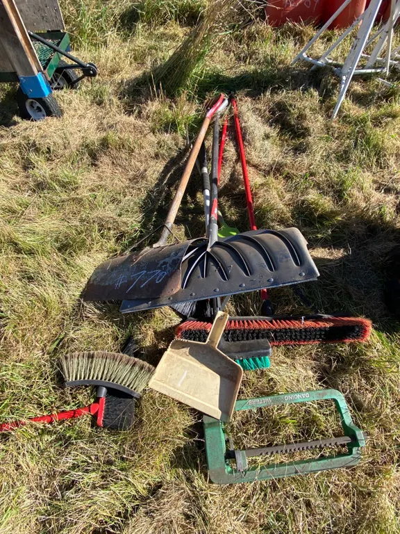 Pile of snow shovels, brooms, dust pans etc.