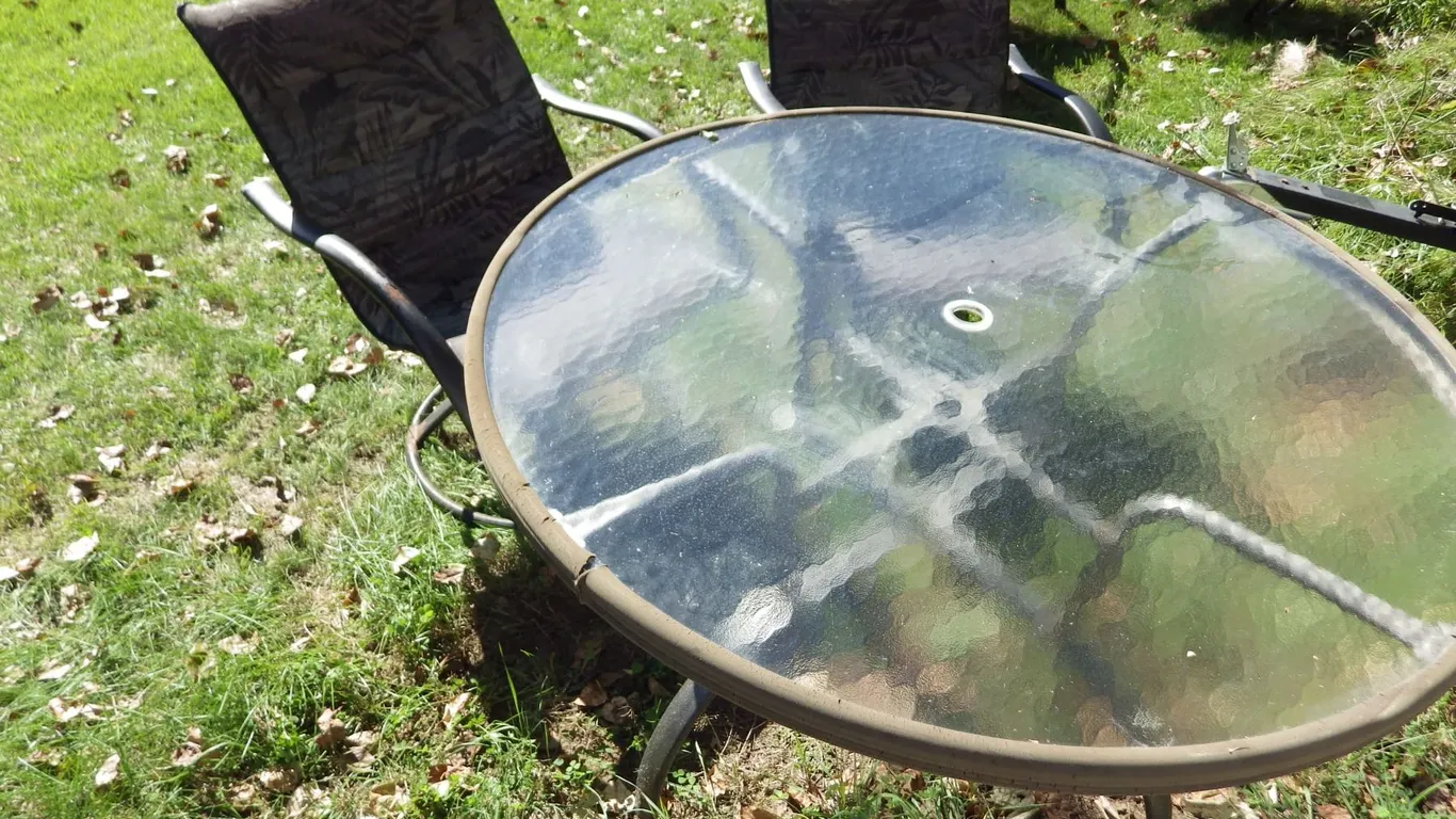 round glass topped patio table and 2 chairs