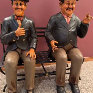 Seated Comedic Figures in Bowler Hats on Metal Bench