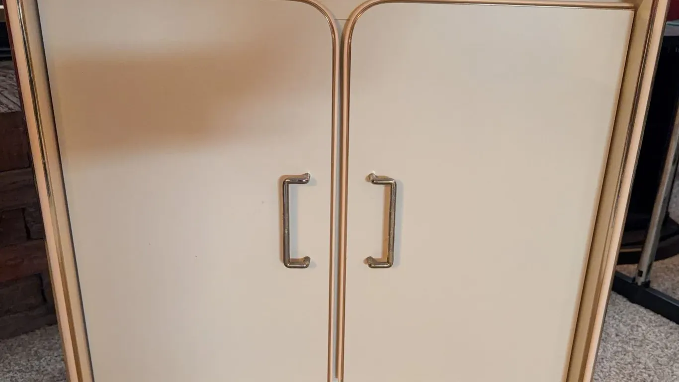 Metal Cabinet With Shelf and Dual Doors, Cream Finish With Gold Accent Trim