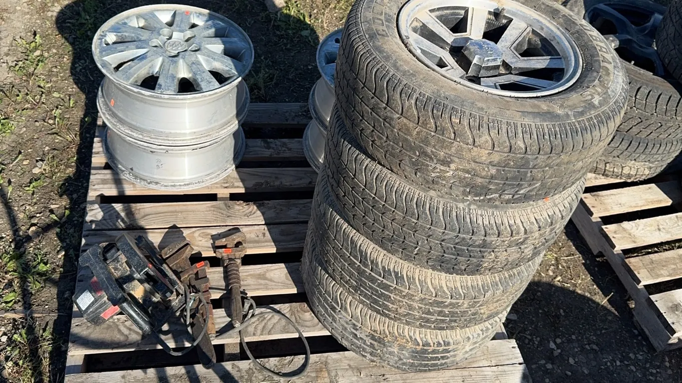 4 tires on rims P225/60R14, 4 buick rims, 3 monkey wrenches, corded Craftsman circular saw,
