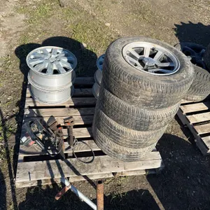 4 tires on rims P225/60R14, 4 buick rims, 3 monkey wrenches, corded Craftsman circular saw,