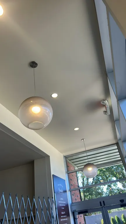 Ceiling hanging pendant lights. Features spherical textured glass shades with bottom openings, cord suspension, and circular metal ceiling canopies.