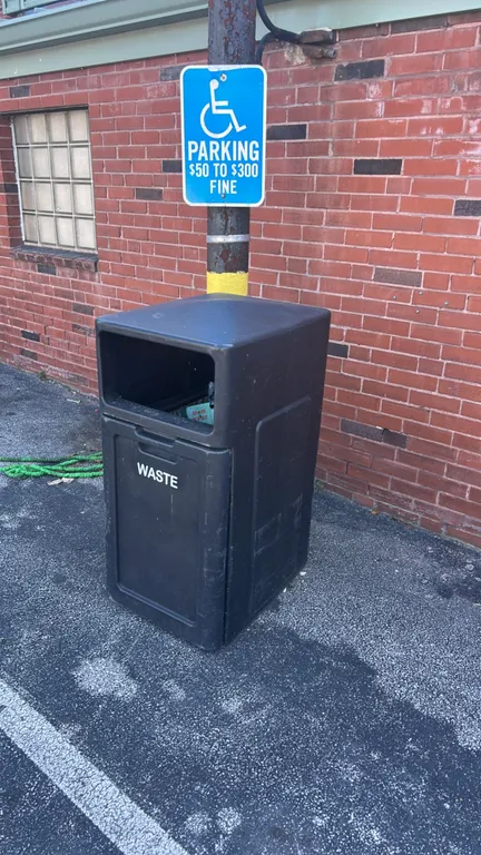 Polyethylene outdoor trash bins. Features molded plastic construction with hooded top disposal openings. Includes one black bin with front-access door