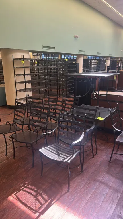 Metal patio dining tables with chairs. Features square metal mesh tabletops with center umbrella holes. Includes matching metal armchairs with slatted