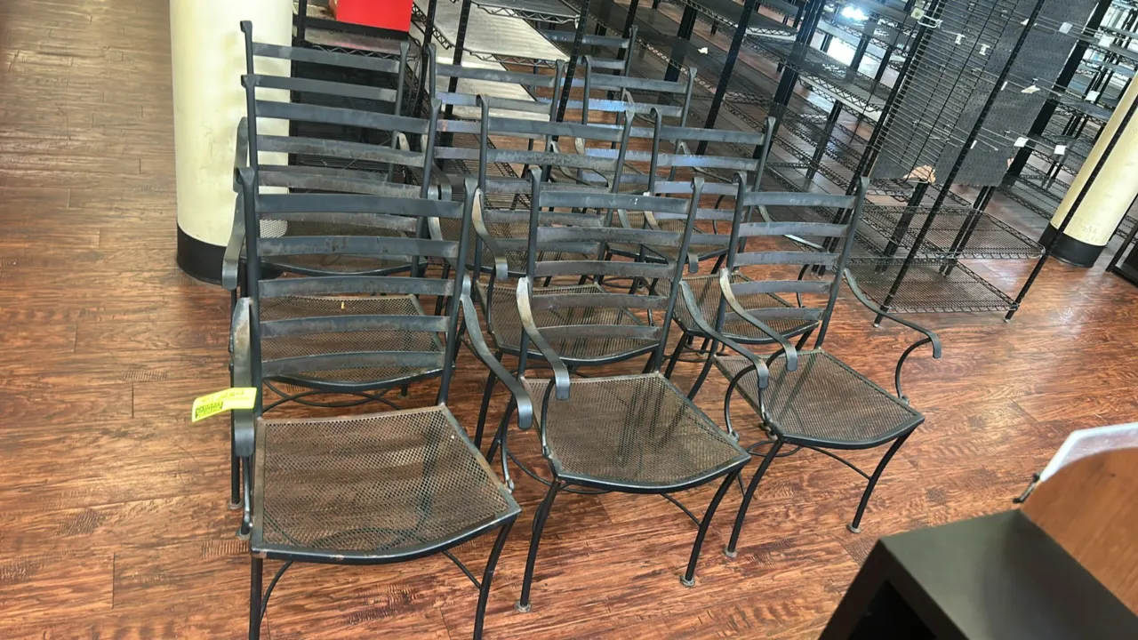 Metal outdoor patio armchairs. Features black metal construction, horizontal slat backrests, expanded mesh seats, and curved armrests.