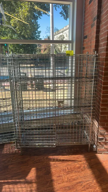 Metro multi-tier chrome wire security cage. Features double hinged front security doors with latch handle, wire mesh enclosure, and (4) wire shelves.