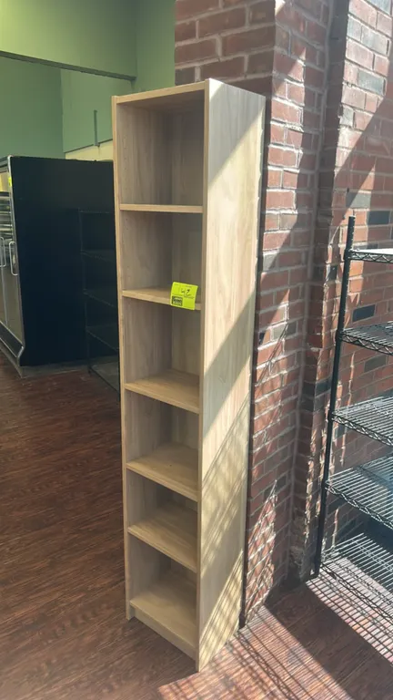 Laminate multi-tier bookcase shelving unit. Features light woodgrain finish and 6-tier storage with adjustable shelving. Dimensions: 16" x 11".
