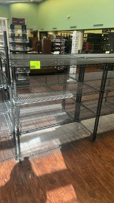 Metro 5-tier wire shelving rack. Features black metal wire construction with (5) adjustable wire shelves (three black and two chrome) and a clear bott