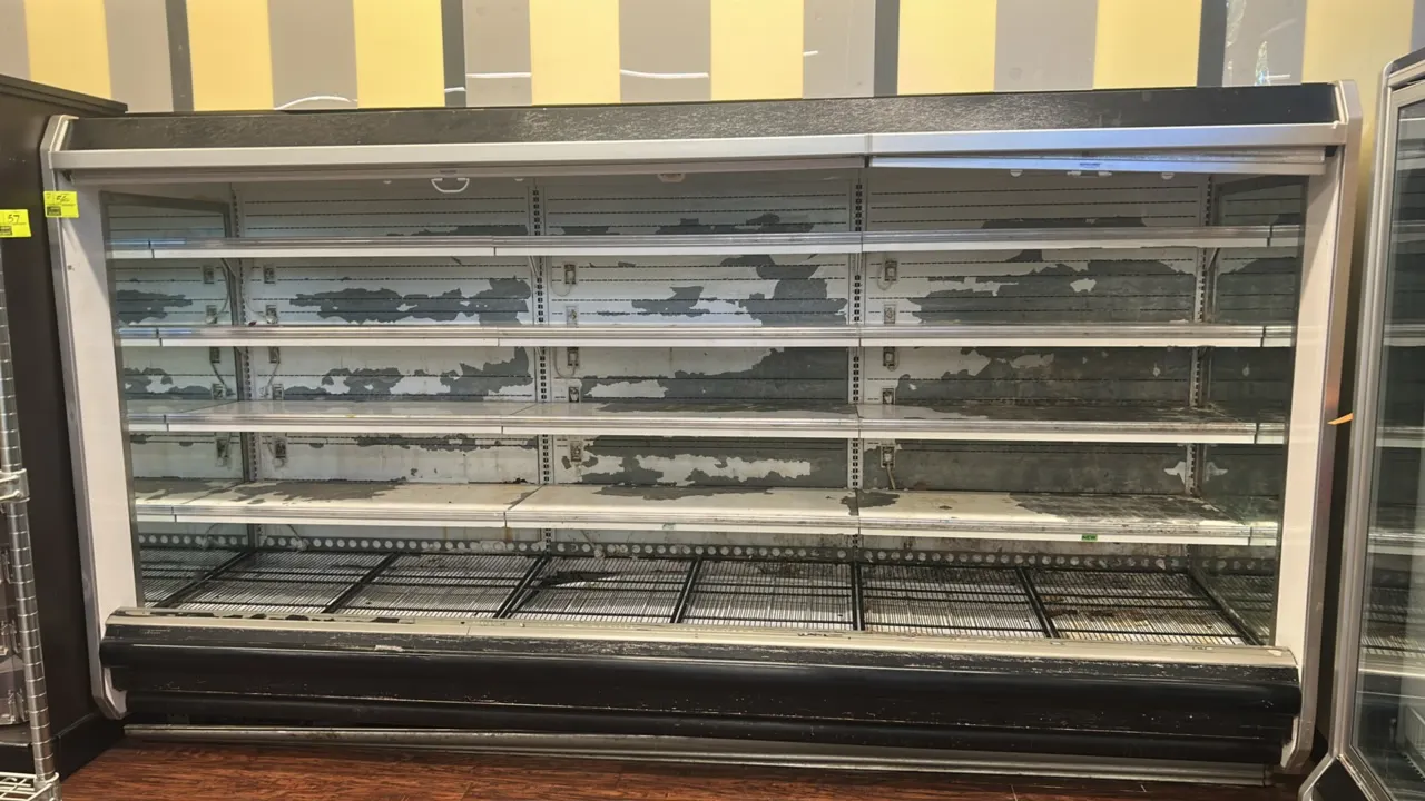 Hussmann D5-12L U medium-temp multi-tier open display case. Features 4 tiers of solid shelving, bottom wire display racks, mirrored interior end panel