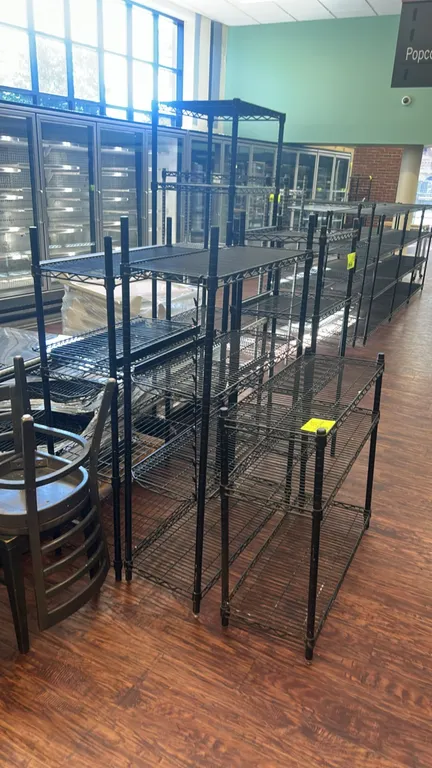 Metal wire multi-tier racks. Features black finish wire construction, multi-tier wire shelves, and tubular upright posts with adjustable leveling feet