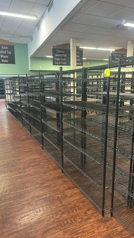 Metro multi-tier wire shelving racks. Features black wire construction, adjustable shelves including slanted display tiers with front retainers, and r