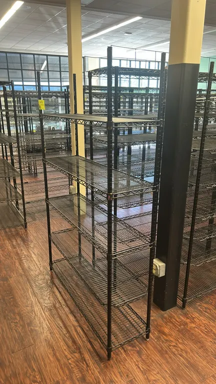 Metro metal wire multi-tier shelving rack. Features black finish, adjustable wire shelves, and leveling feet. Dimensions: 48" x 14".