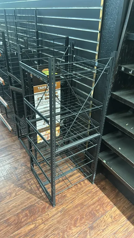 Metal wire multi-tier merchandisers. Features black metal construction, multi-tier wire display shelves with integrated shelf label channels, and wire