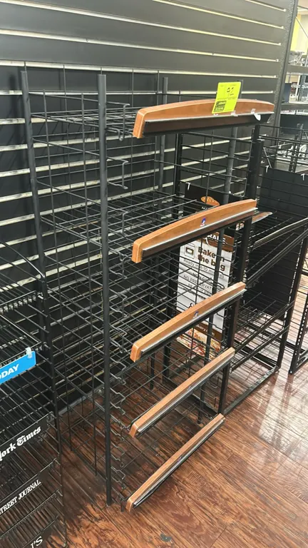 Metal wire multi-tier display merchandiser. Features 5 wire shelves with woodgrain front trim and integrated price tag molding, black metal wire frame
