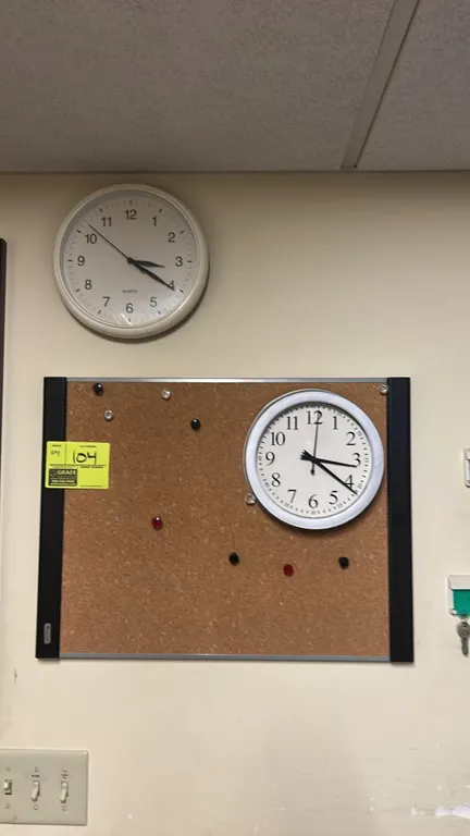 Quartet cork bulletin board with (2) analog wall clocks. Board features an aluminum and plastic frame with assorted push pins. Clocks feature round fr