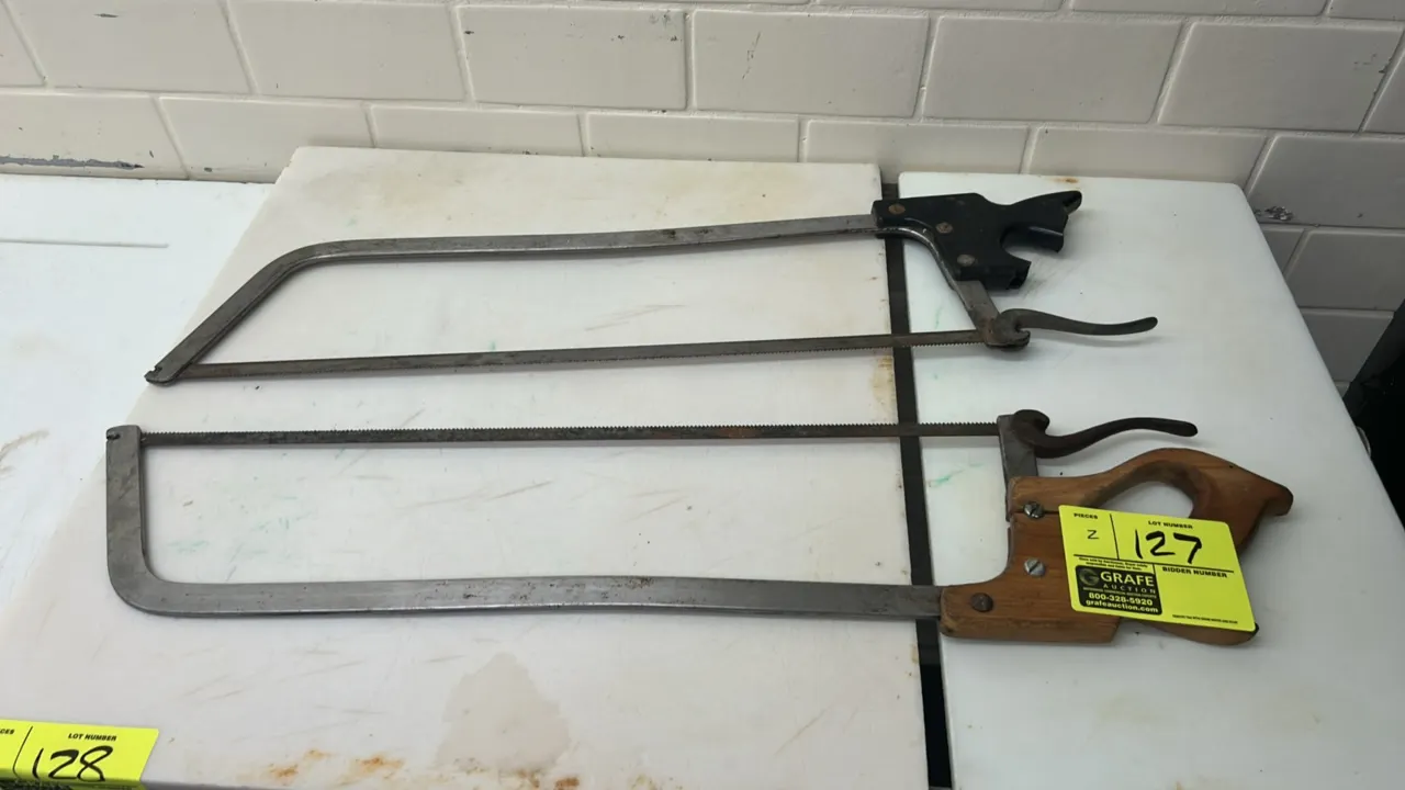 Meat and bone hand saws. Features steel frames with cam-action blade tension levers. Includes one saw with a contoured wooden handle and one saw with