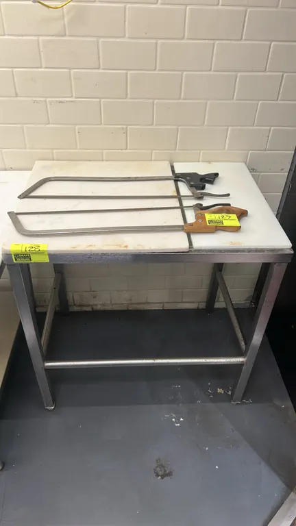 Stainless steel work table with poly top. Features poly cutting board surface and stainless steel frame with tubular cross-bracing. 34" x 24". Note: S