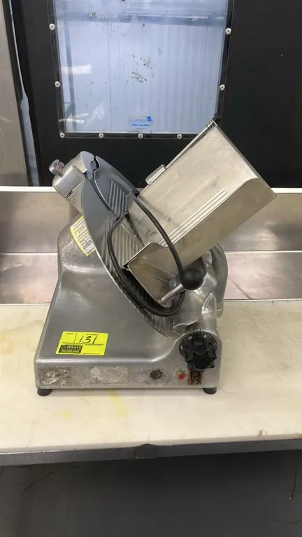 Berkel commercial deli meat slicer. Features an angled gravity-feed product carriage, product pusher, slice thickness adjustment knob, and blade guard