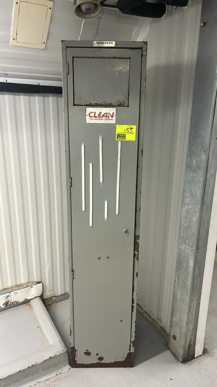 Change-O-Matic metal uniform drop locker. Features top deposit door, full-length hinged access door, and gray metal construction. Note: Shows heavy ru